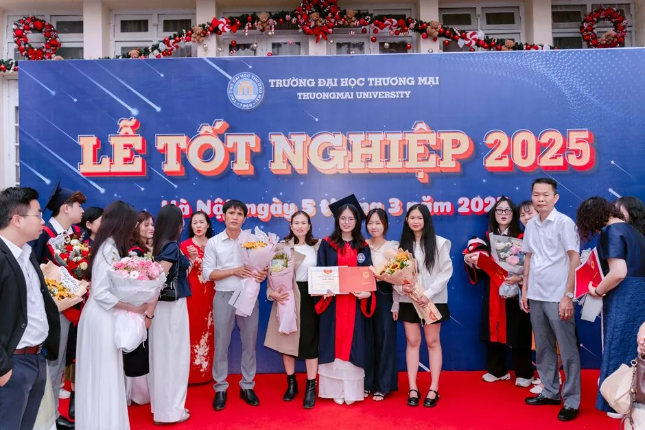 Group of graduates celebrating at Thuongmai University 2025 ceremony.