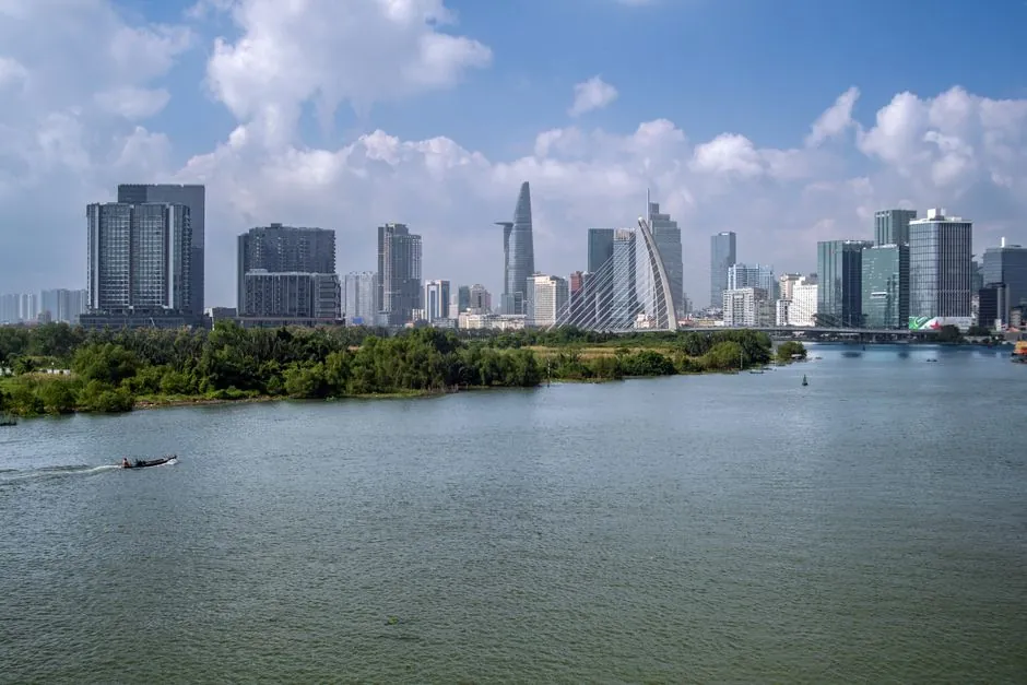 Scenic view of Ho Chi Minh City skyline with Saigon River and modern architecture.