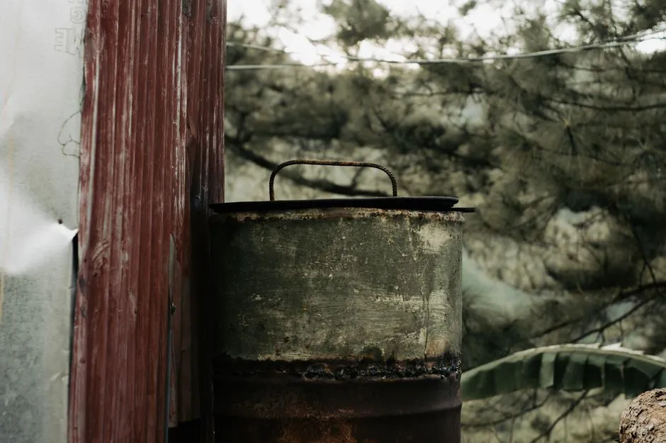 A rustic scene with an old barrel and weathered wall in a natural outdoor setting.